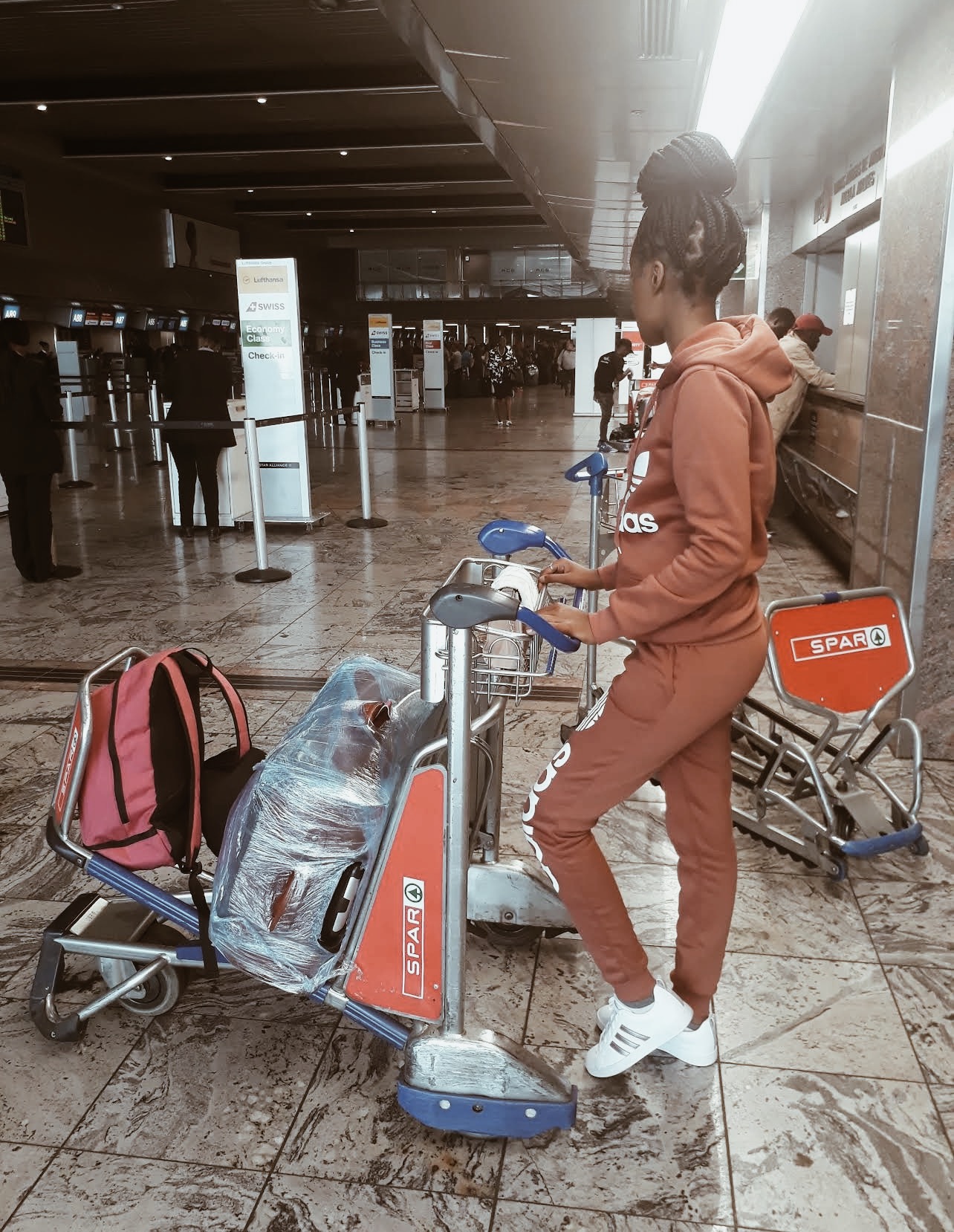 A picture of a young woman at the airport waiting to check in