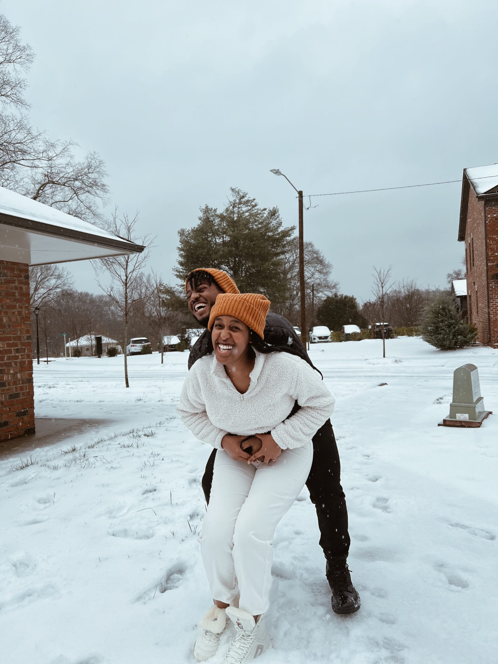 Young woman and man laughing and playful in the snow