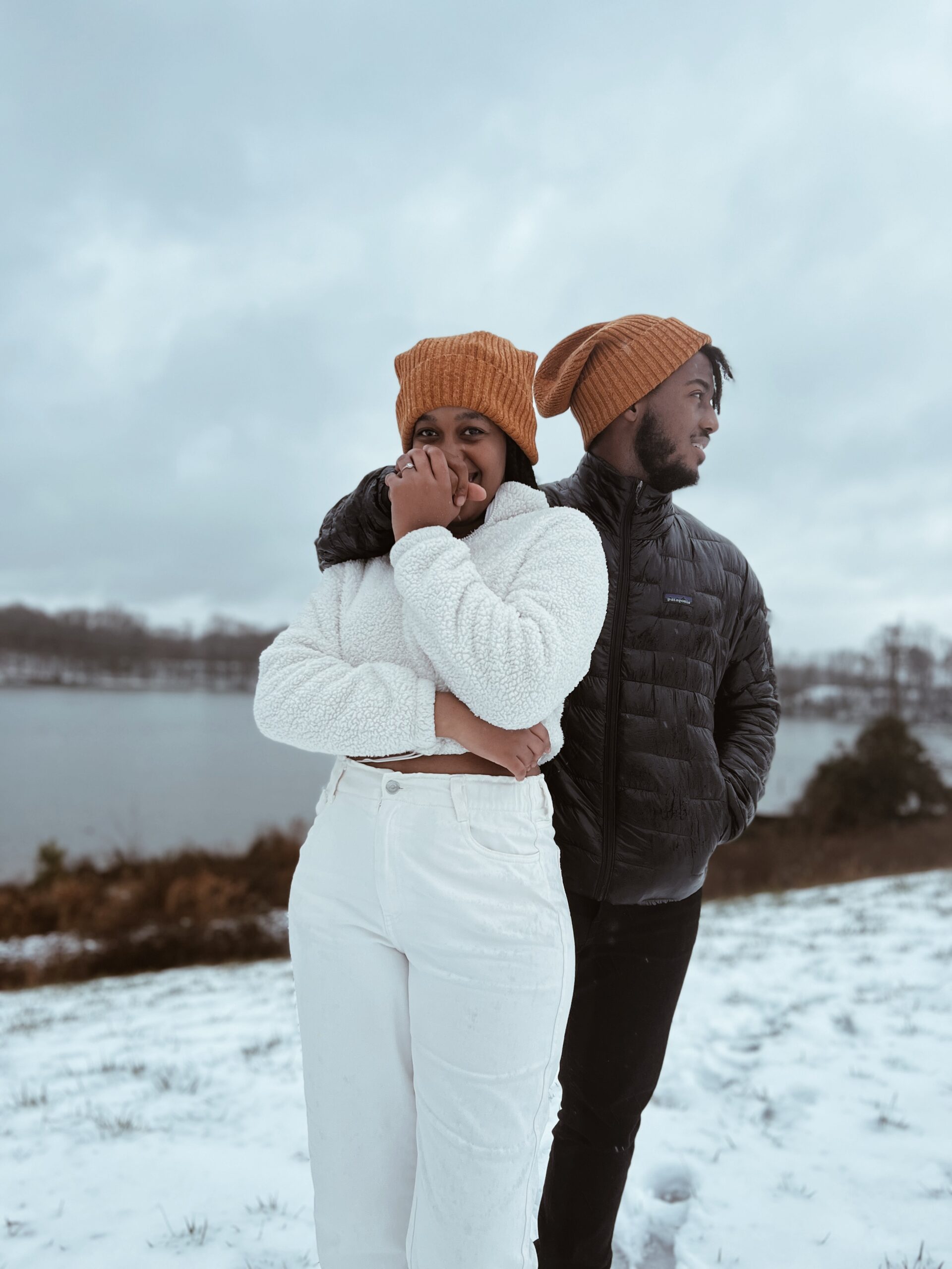 Young woman and man posing at at the camera in the snow