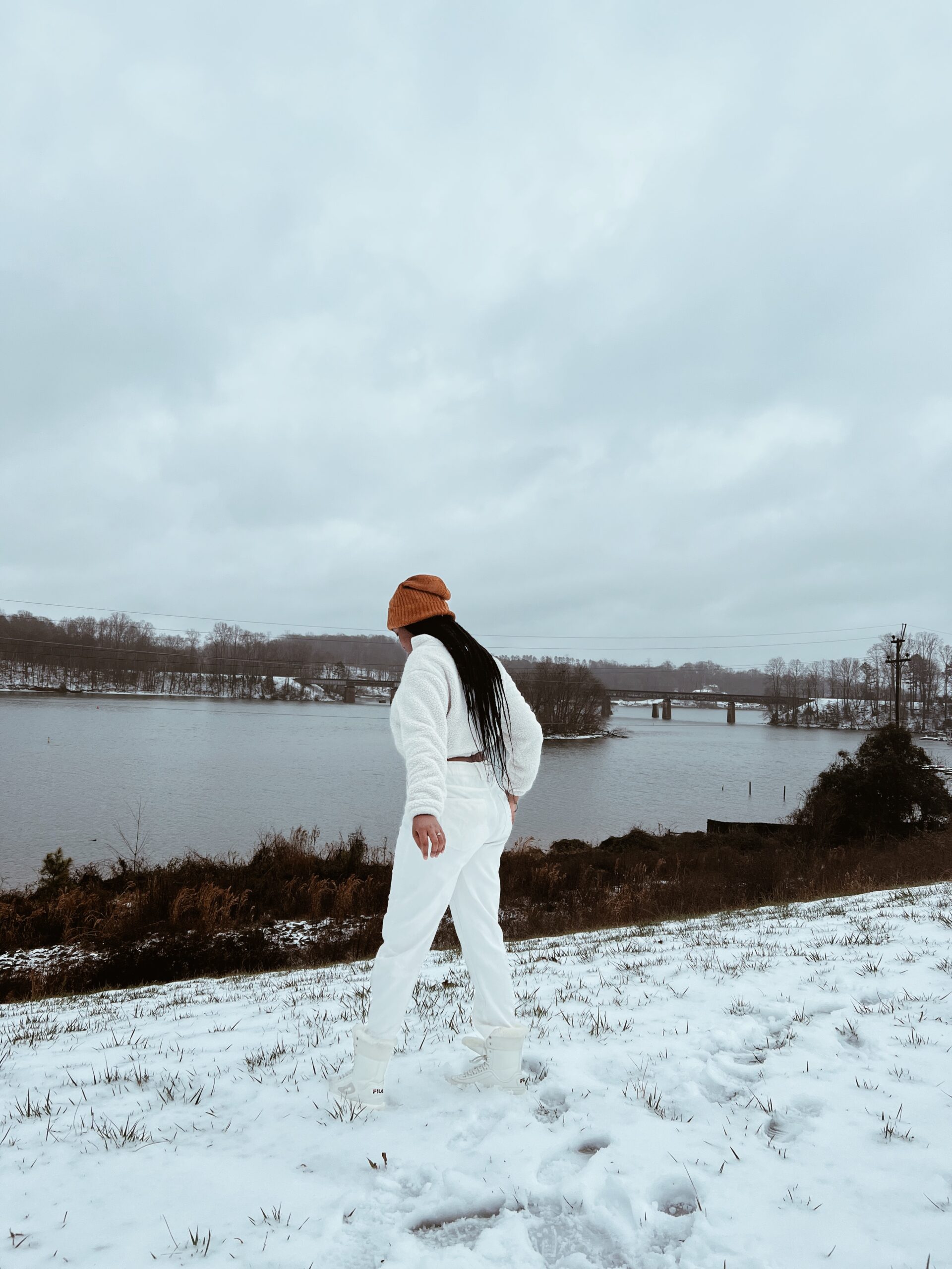 Young woman facing towards the river in the snow