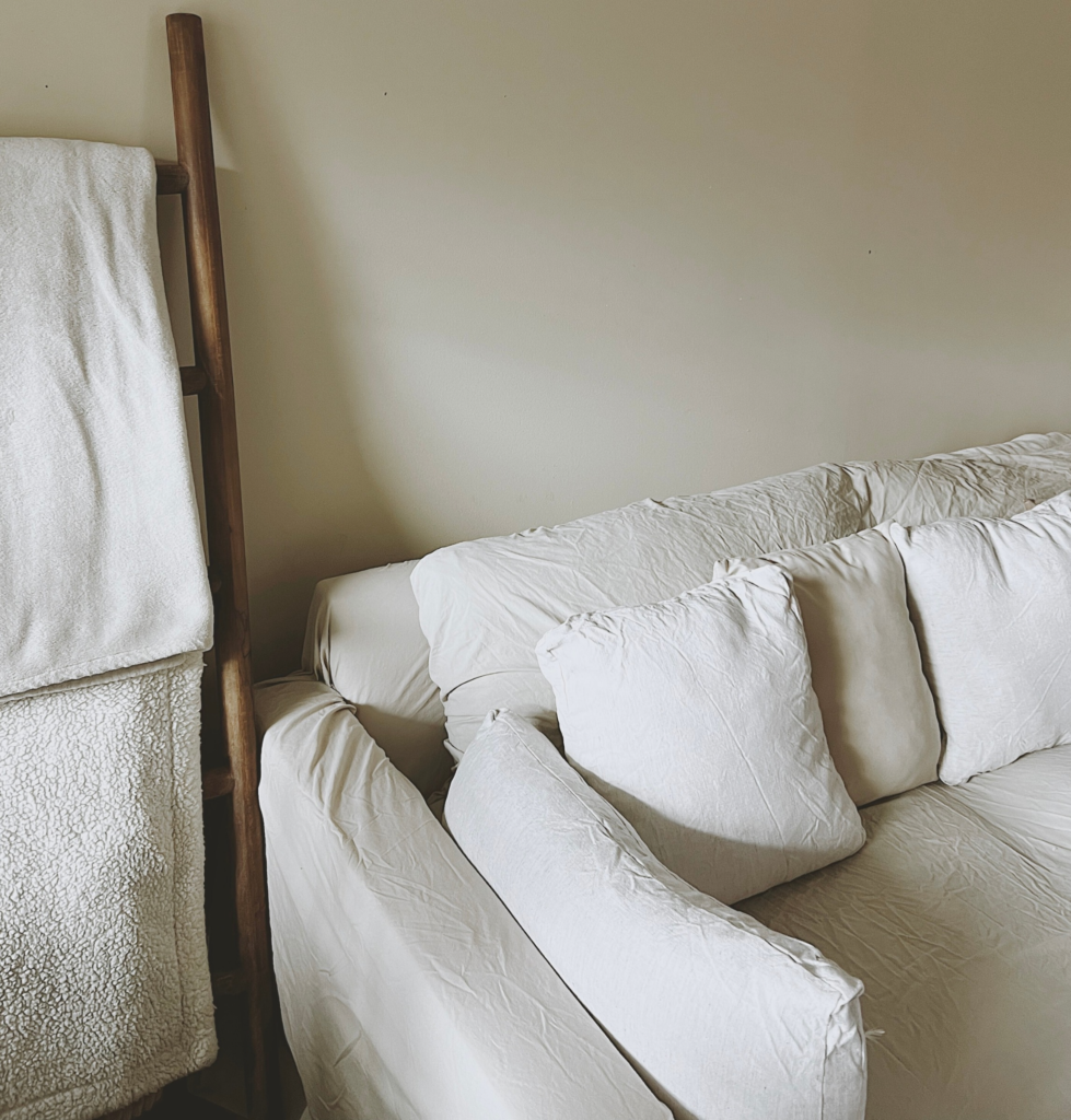A modern linen couch with a blanket
