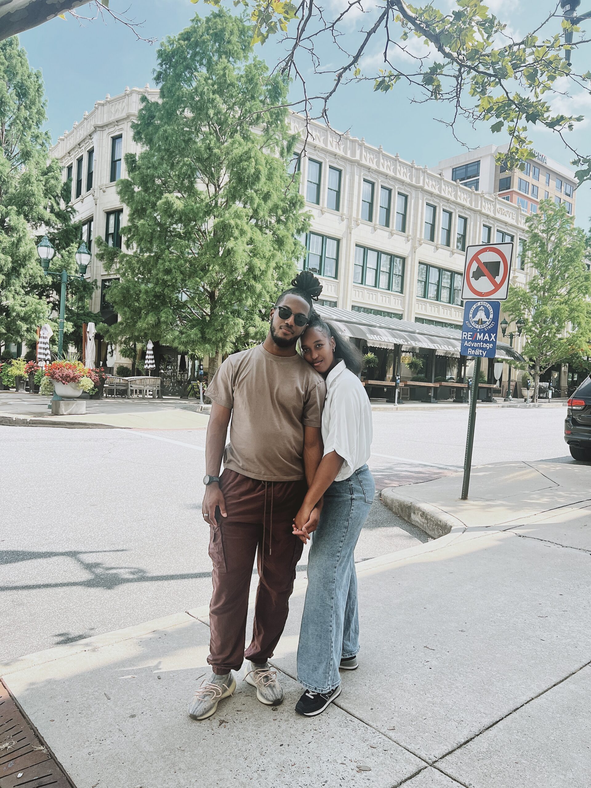 Couple posing for a photo in front of the Battery Park Book Exchange Bar 