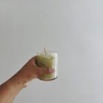 Woman holding a glass with iced matcha latte