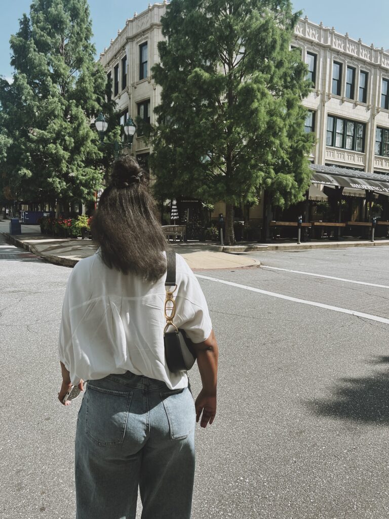 Woman standing in front of a building on a hot summer day