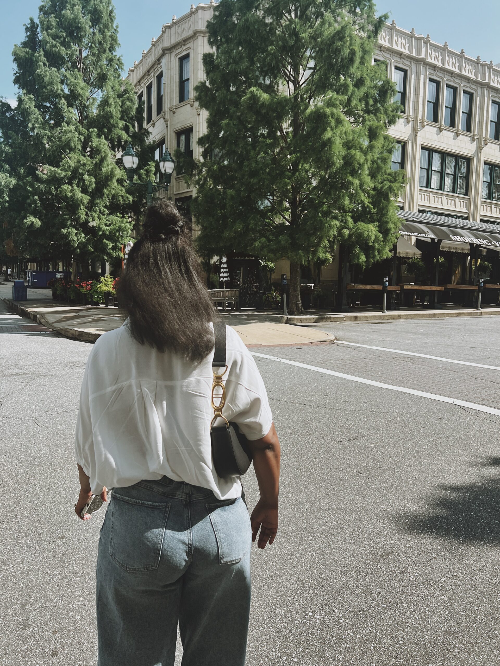 Woman standing in front of a building on a hot summer day