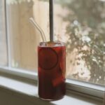 Raspberry leaf tea for period cramps in a glass, displayed by the window